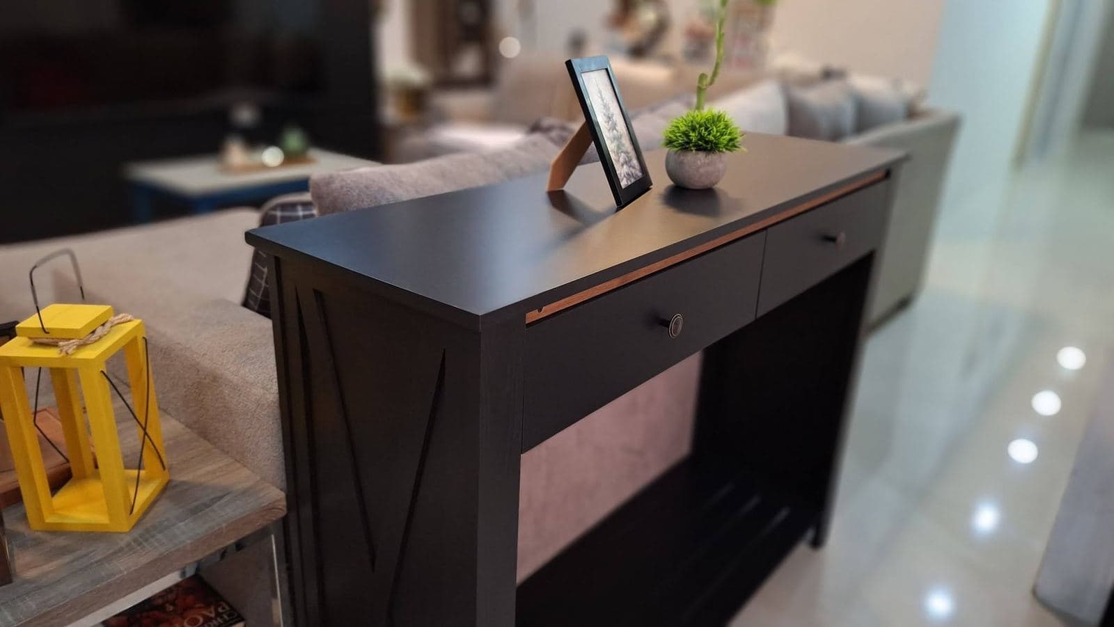Matte black two-drawer console table with walnut-lined drawer pulls in a living room