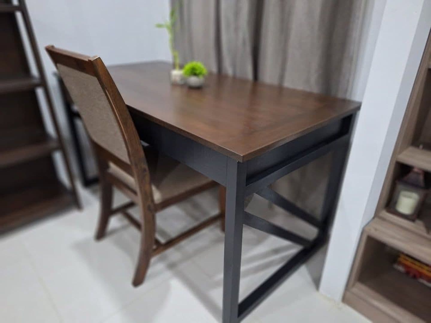 Walnut-top writing desk on black X-braced legs with a woven-back chair